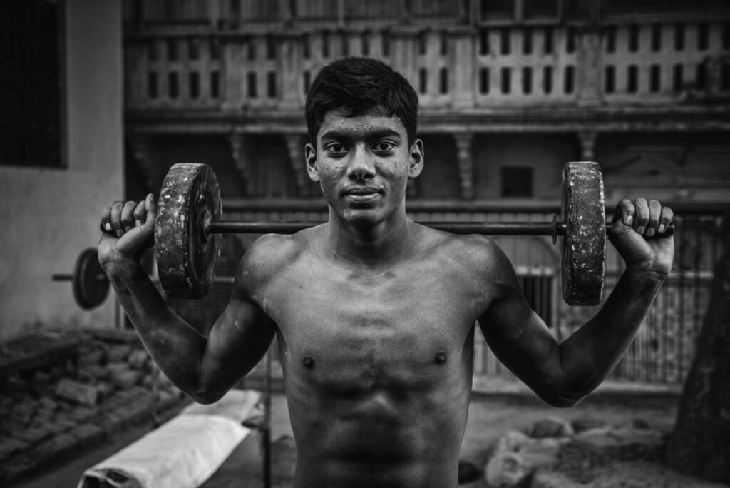 Indyjski sportowiec trzymający sztangę