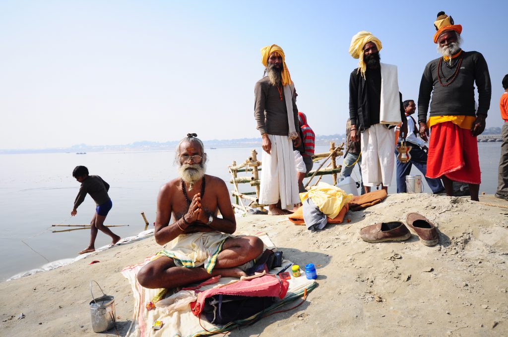 Mężczyzna siedzący po turecku na plaży indyjskiej